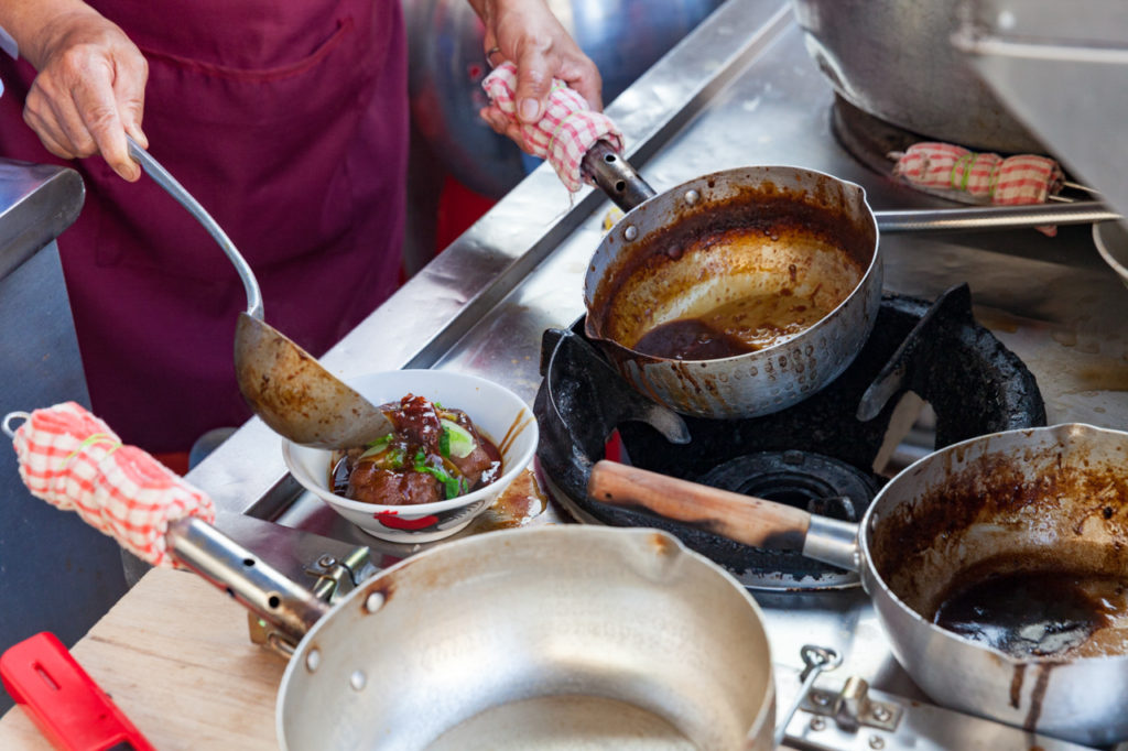 Woman cooks duck meat at Kimberly Street Food Night Market