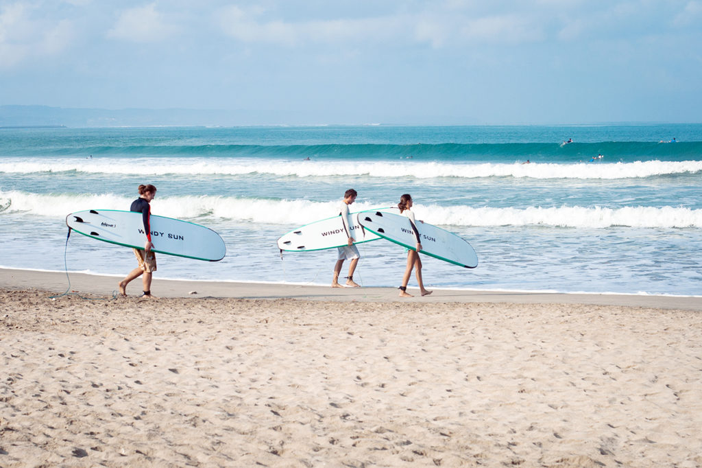 Novice surfers are going to catch the wave at the Kuta beach, Bali, Indonesia